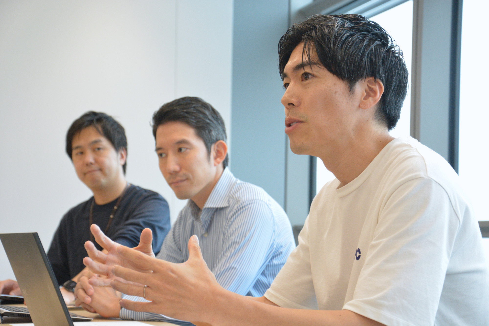 会議室で話し合う荒木さん、井上さん、大門さん
