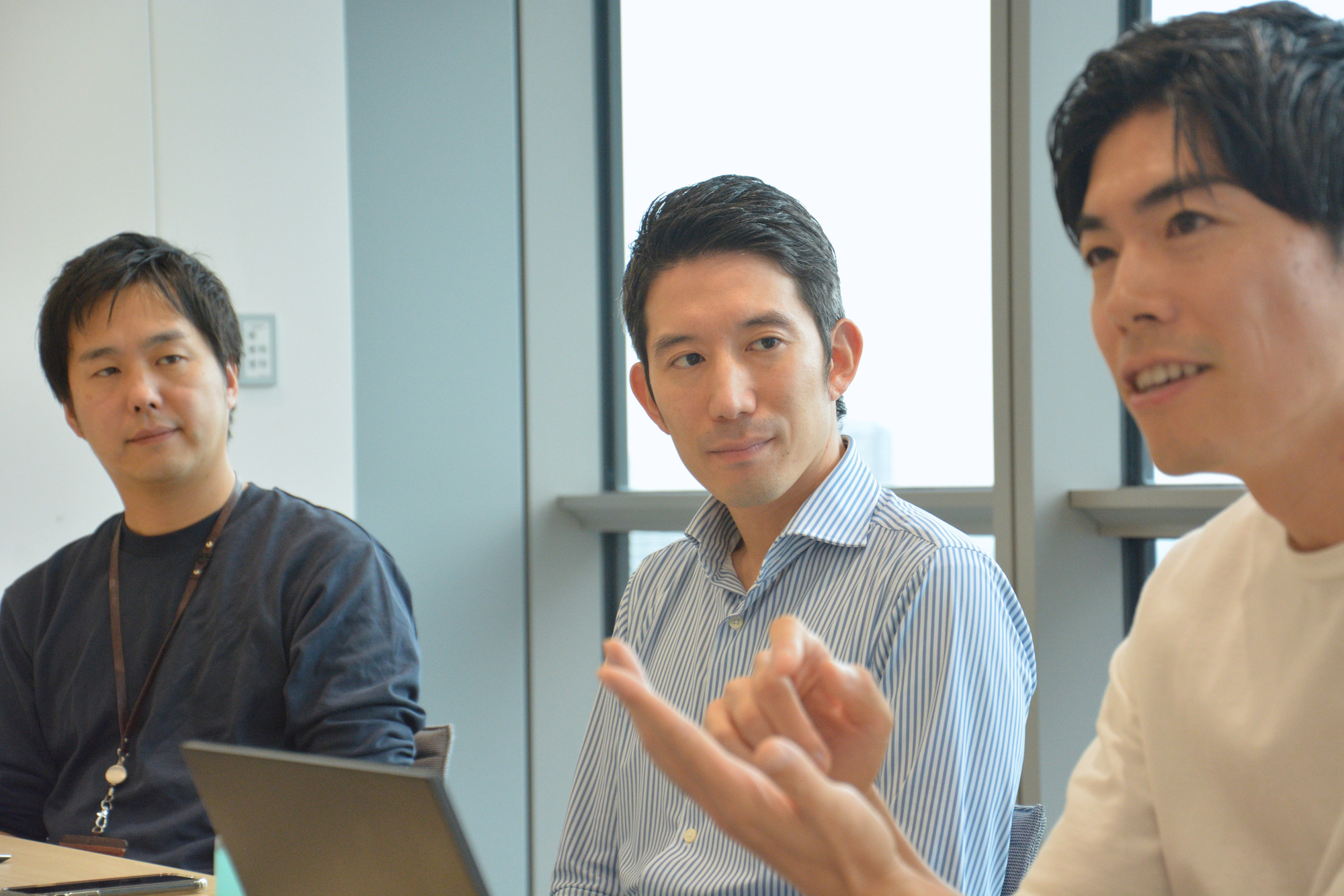 会議室で聞き手に向き合う荒木さん、井上さん、大門さん